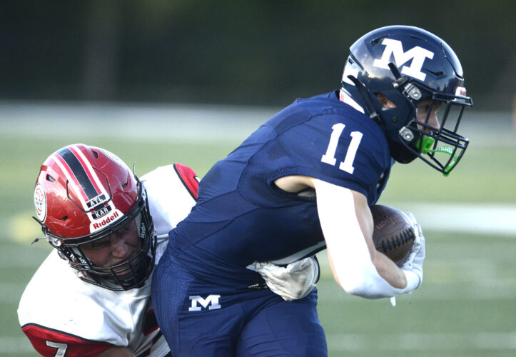 Staff file photo / R. Michael Semple McDonald running back Casey Miller (11) is wrapped up for a tackle by Columbiana’s Jensen Nordquist during the first half of a game on Aug. 29 in McDonald.